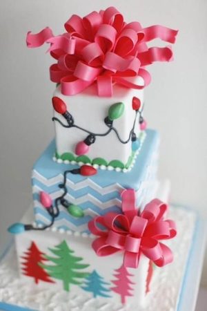 A three-tiered Quinceanera cake decorated with Christmas lights