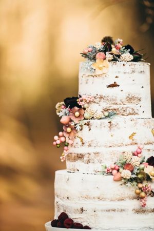 Quinceañera cake, a three-tiered cake with flowers on top in a nature-themed setting
