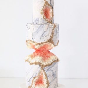 A three-tiered Quinceanera cake with red and white frosting