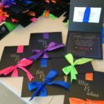 A festive Quinceanera party with a table topped with lots of different colored cards and a ribbon