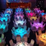 Quinceañera dresses in a glow-in-the-dark theme, with a room full of tables and chairs