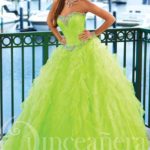 A woman posing for a picture in a green gown Quinceañera dress