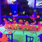 Neon Quinceañera, a table with a centerpiece and decorations on it