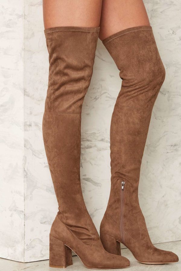 A close up view of a woman's legs wearing knee-high boots made of thigh suede, perfect for a Quinceanera celebration.