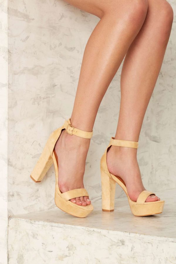 A close up of a woman's legs wearing high heels, high heeled footwear