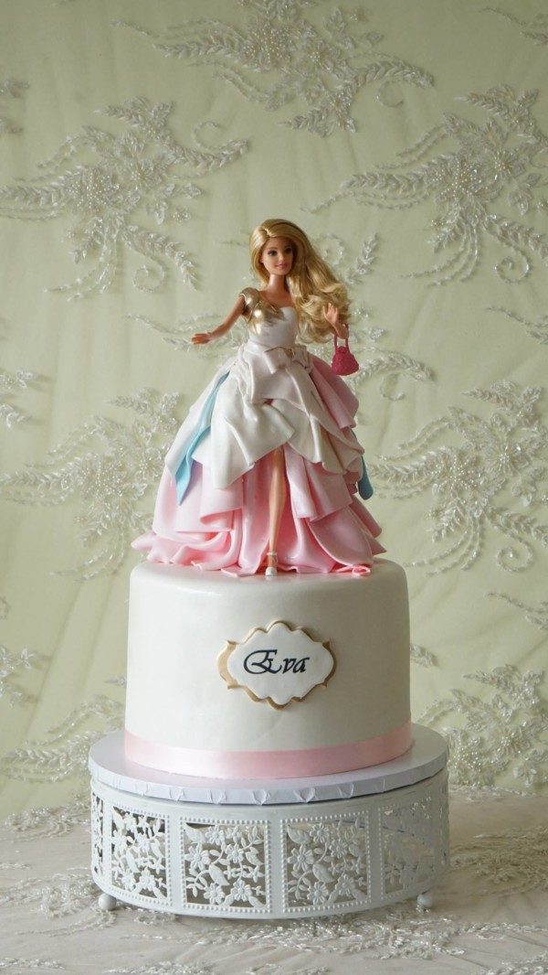 A Quinceanera doll cake with a Barbie doll on top of it