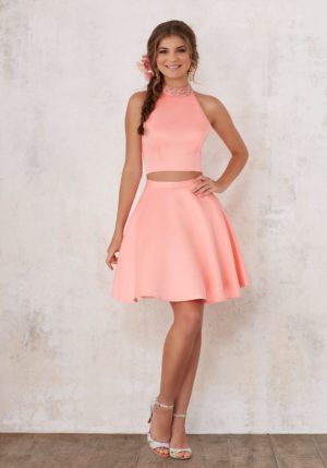 A woman wearing a coral Quinceanera damas dress, a pink two-piece dress