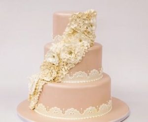 A beautiful Quinceanera cake, three tiers high with white flowers adorning the top