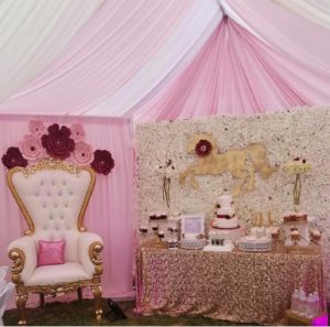 A Quinceanera celebration in a room decorated with pink and gold, featuring a horse theme