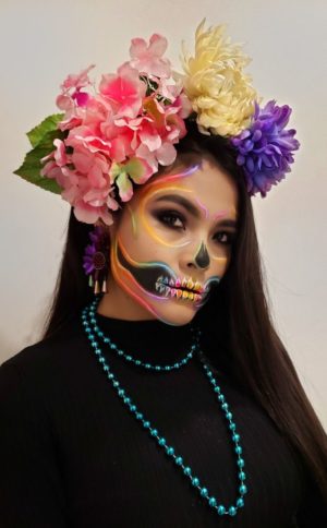 A woman with a flower crown on her head, wearing makeup and a headpiece
