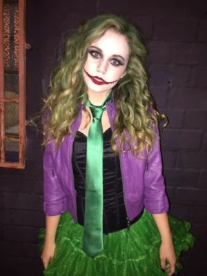 A Quinceanera woman dressed as a joker with a green skirt costume