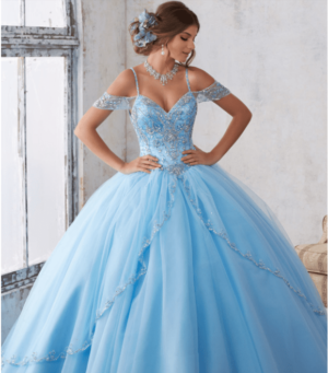 A woman in a blue Quinceanera gown posing for a picture