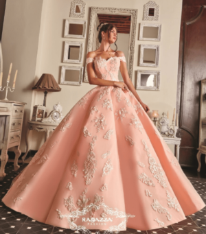 A woman in a pink Quinceanera dress standing in a room