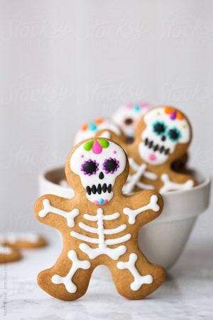Quinceanera-themed image of a Gingerbread man surrounded by Day of the Dead sugar skulls.
