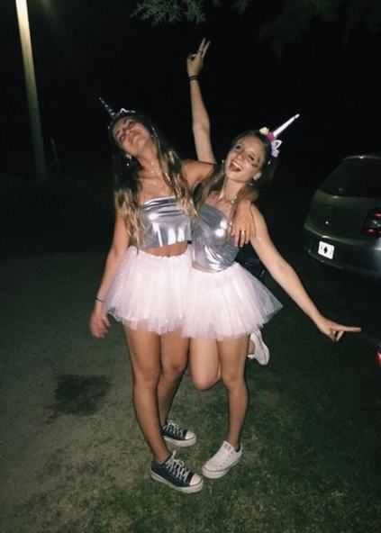 Two women dressed up in tutus posing for a Quinceanera picture