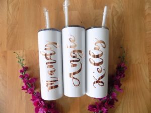 A group of three candles sitting on top of a wooden table with Quinceanera drinkware