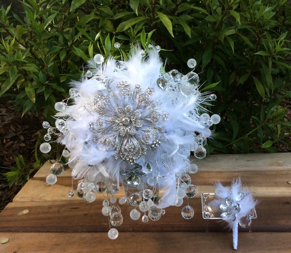 A beautiful floral design featuring a bouquet of white feathers and beads on a wooden table, perfect for a Quinceanera celebration.