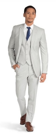 A man standing in a gray suit and blue tie at a Quinceanera.
