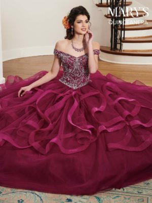 A woman sitting on the floor in a purple Quinceanera gown dress
