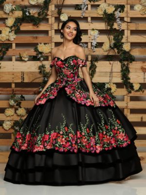 A woman in a black and red Quinceanera dress standing in front of a wooden wall