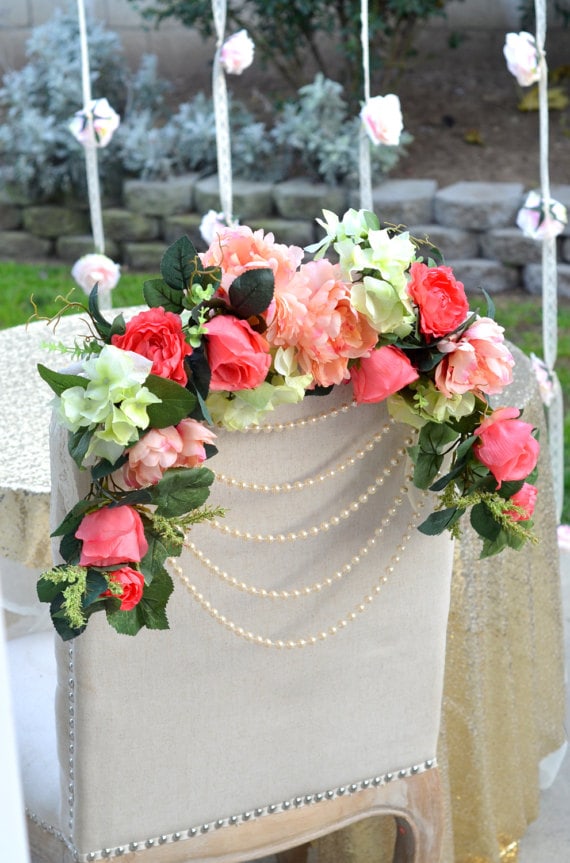 Floral design with a flower bouquet on a table and a chair adorned with flowers and pearls for a Quinceanera celebration