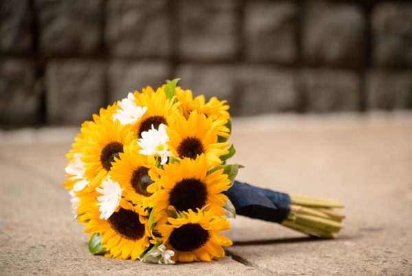 Samsung AU7000 (2021), a Quinceanera bouquet of sunflowers is laying on the ground.