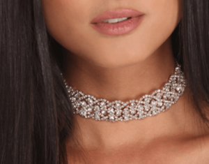 A close up of a woman wearing earrings and a necklace for a Quinceanera