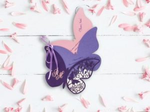 A Quinceanera invitation featuring a purple and pink paper butterfly on a white background