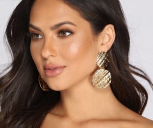 Quinceanera: A woman with long hair wears gold earrings.
