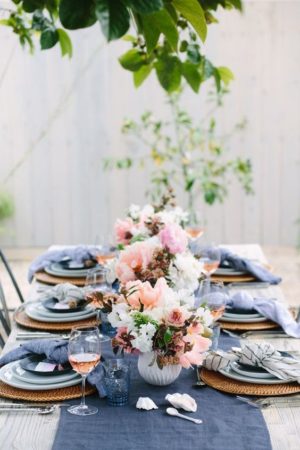 A Quinceanera summer dinner table set with plates and decorations