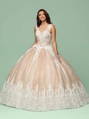 A woman in a ball gown standing in front of a green background, wearing a Quinceañera dress