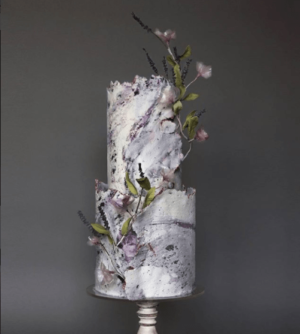 A Quinceanera themed cake, featuring a three-tiered design adorned with beautiful flowers