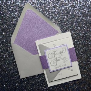 A lilac Quinceañera wedding invitation with a purple ribbon and silver accents.