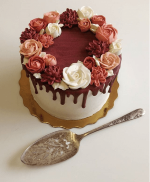 A Quinceanera-themed image of a torte wine, a red and white cake, and a spoon on a table
