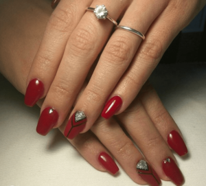 Close up of a person's hands with red nails at a Quinceanera