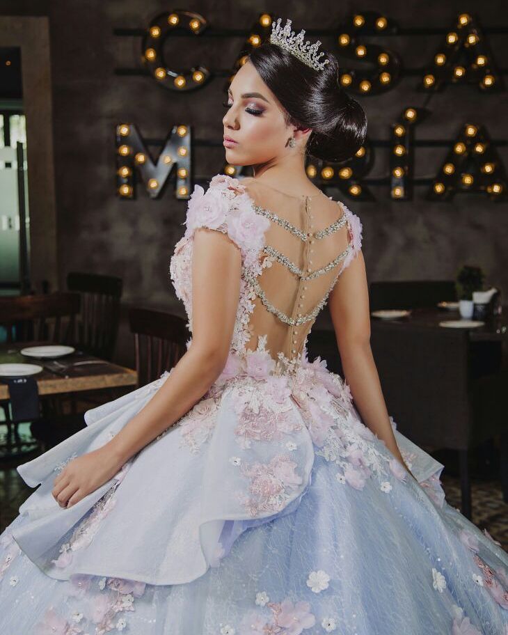 A woman wearing a blue and pink Quinceanera gown