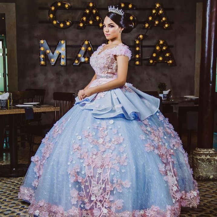 Two Quinceañera dresses, one in light blue and one with a tiable bow worn by a woman