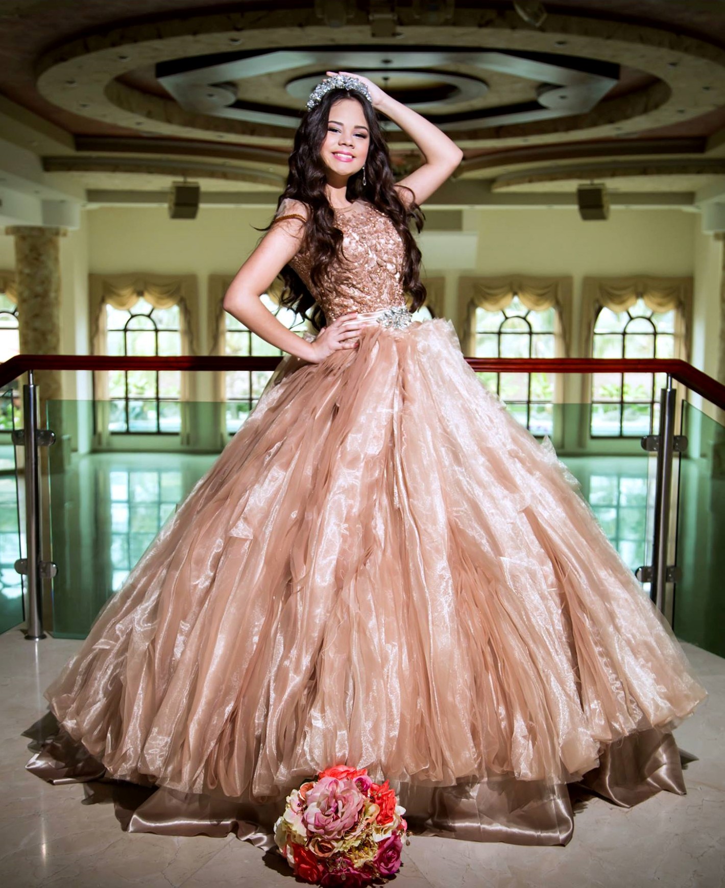 A Quinceanera woman in a ball gown posing for a picture