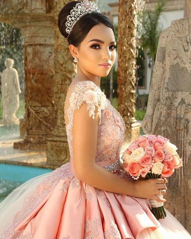 A Quinceañera girl in a pink dress holding a bouquet