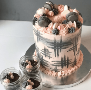 A Quinceanera themed image featuring a chocolate cake with pink frosting and chocolate cupcakes