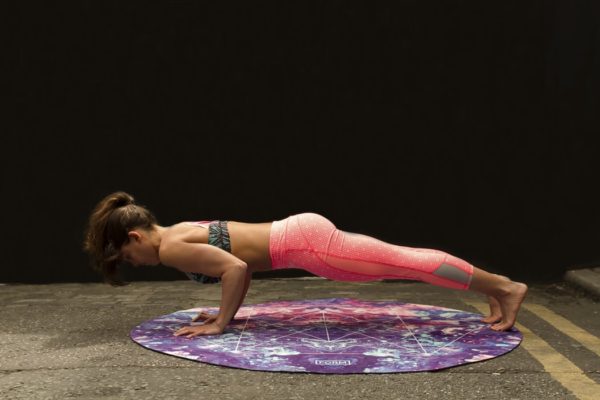A woman doing a yoga pose on a mat during a Quinceanera celebration
