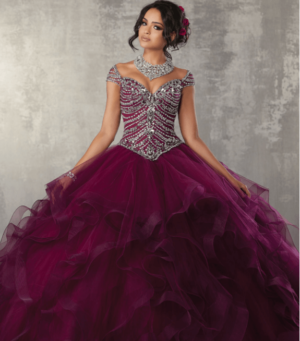 A woman in a magenta Quinceañera dress posing for a picture