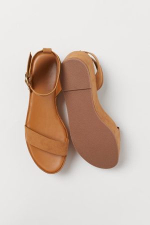 A pair of tan sandals on a white surface
