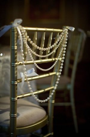Quinceanera decor ideas with pearls, a close up of a chair adorned with pearls
