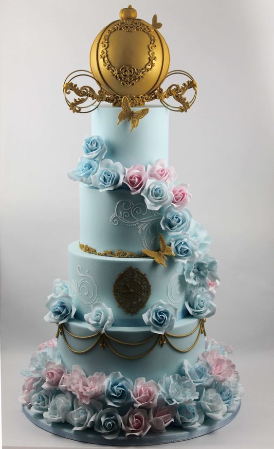 A three-tiered Quinceanera cake decorated with blue and pink flowers