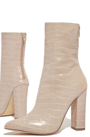 A pair of nude-colored ankle boots with high heels, perfect for a Quinceanera celebration