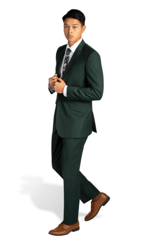 A man standing in a green suit and brown shoes at a Quinceanera event.