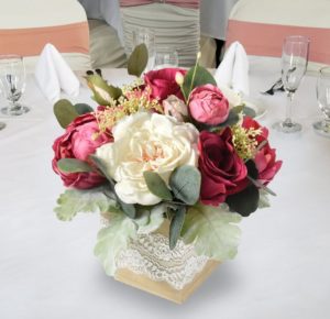 A table decorated with a floral design, featuring a vase of flowers