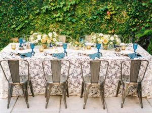 A Quinceanera-themed table with a bunch of chairs and a table cloth
