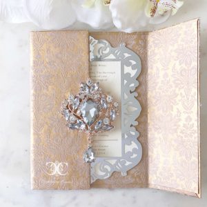 A Quinceanera card with a brooch on top
